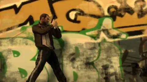 Niko walks along a grafitti covered wall, gun drawn.