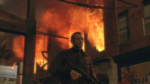 Niko walks past a burning building