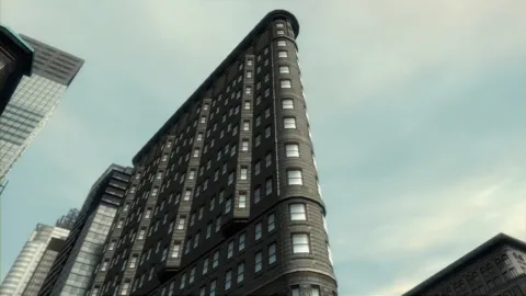 A triangular building separates two streets.