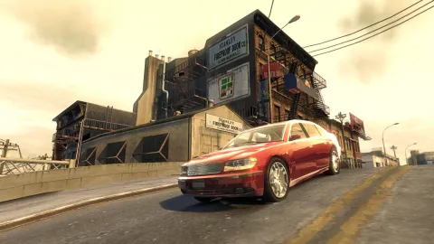 A red car drives down a short hill.