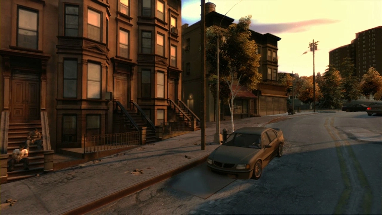An old looking car drives down a worn street past some houses.