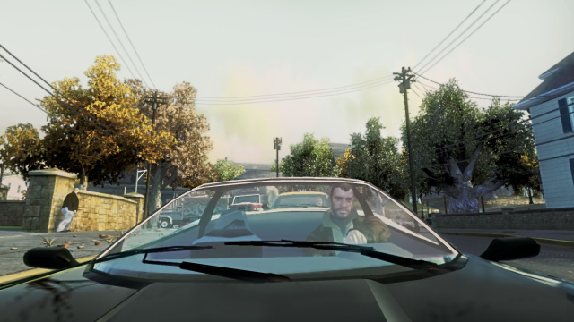 Niko drives a black car through a residential area.